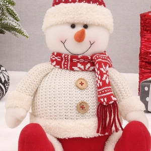 Detailed view of a red and white knitted snowman plush with wooden button accents