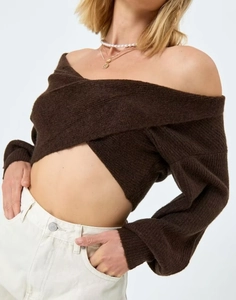 Dettaglio del maglione in maglia marrone con design incrociato sulla schiena nuda