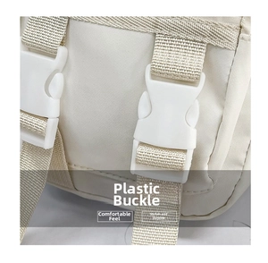 Dettaglio delle fibbie in plastica e tracolla in nylon della borsa beige trendy