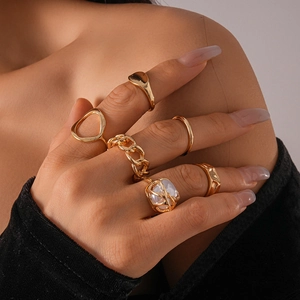 Close-up of five-piece vintage gold ring set with pearl accents worn on fingers