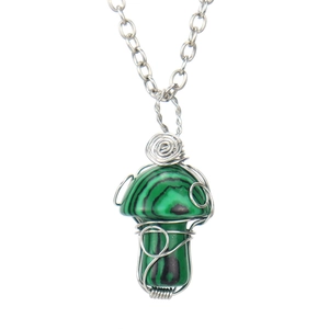 Detailed macro shot of a mushroom pendant with green malachite stone and wire wrapping