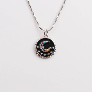 Detail of silver box chain necklace with moon star pendant and black enamel finish