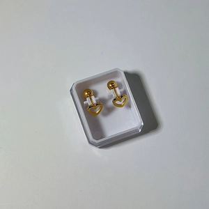 Detail of 18k gold heart earrings with comfortable screw back ball closure in a white box
