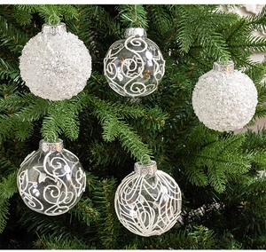 Detail of white beaded and scroll pattern glass Christmas balls on tree branches