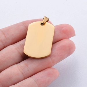 Handheld view of a polished gold stainless steel rectangle dog tag pendant with mirror finish