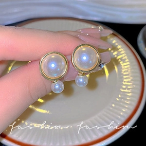 Detailed view of vintage gold hoop earrings featuring elegant double pearl pendants