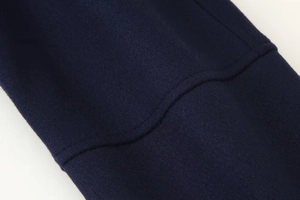 Macro shot of navy blue wool fabric detail with professional curved stitching finish