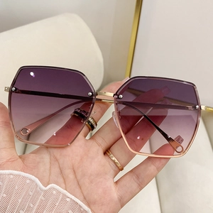 Detailed macro of gradient purple lenses and rimless gold frames on oversized sunglasses