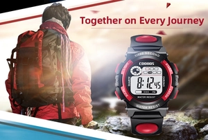 Detail of COOBOS digital sports watch with black and red strap against mountain background