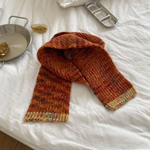 Detailed macro view of multi-colored chunky knit scarf with red and orange vintage texture