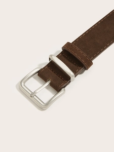 Macro shot of brown suede leather belt with silver pin buckle and stitching details