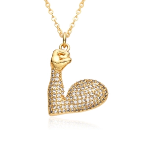 Close-up of golden muscular arm pendant encrusted with sparkling cubic zirconia stones