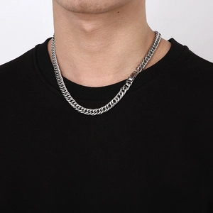 Collier gourmette classique en acier inoxydable argenté sur un sweat noir