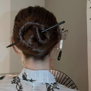 Detail of butterfly tassel hair stick worn on bun with vintage bamboo pattern clothing