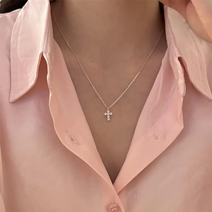 Close-up of minimalist S925 silver cross necklace with sparkling zircon stones on neck