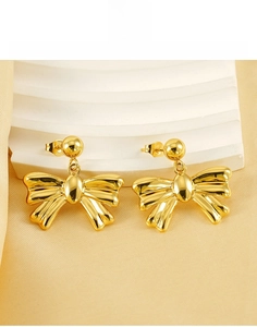 Detail of 18k gold plated bow earrings in stainless steel on silk background