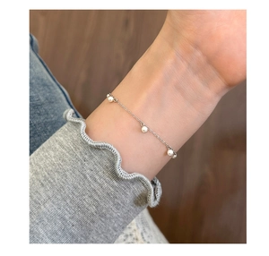 Bracciale minimalista in argento sterling S925 con perle bianche su un polso femminile