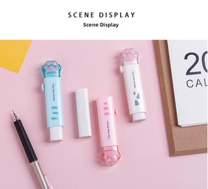 Pastel cat paw erasers in pink and blue on a desk with stationery scene
