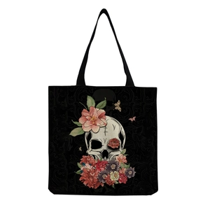 Close-up of skull and floral print on large black canvas tote bag with wide straps
