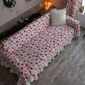 Christmas sofa cover with red ornaments, candy canes and elegant ruffled edge