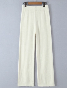 Detail of cream white knit wide-leg pants with elastic waist and soft ribbed texture