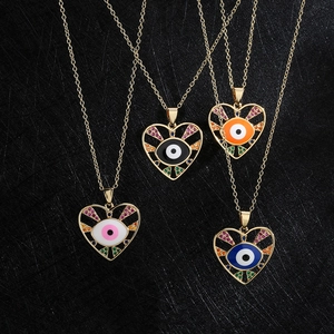 Golden heart-shaped evil eye pendant necklaces with colorful zircon stones on black background