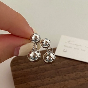 Detail of silver double sphere drop earrings with a polished metallic finish