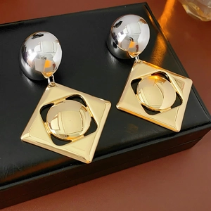 Detail shot of two-tone gold and silver geometric earrings on black leather display