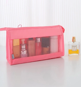 Pink mesh travel toiletry bag showing internal skin care bottles and travel label detail