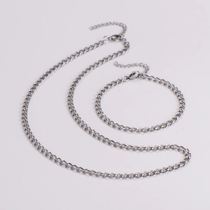 Polished silver 4mm flat curb chain necklace and bracelet set on white background