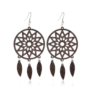 Detailed view of dark brown dreamcatcher wood earrings with star carving and leaf charms