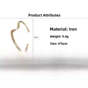 Detail view of wavy gold-tone open cuff bracelet with iron material specs and dimensions