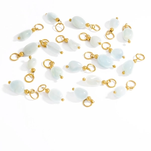Detail of light blue and opal teardrop stone pendants with golden metal loops for DIY jewelry
