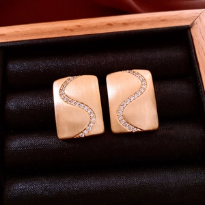 Close-up of 18K gold plated rectangular earrings with S-curve zircon inlay details