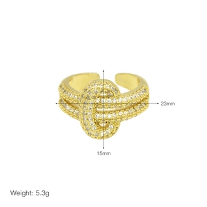 Detail shot of gold-plated knot ring with clear cubic zirconia micro-paving on a white background