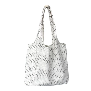 Minimalist black polka dot canvas tote bag with long shoulder straps on white background