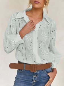 Detail of light green blouse with floral embroidery and hollow stripe bubble sleeves