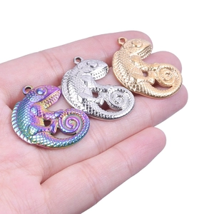 Detailed macro view of three 18k gold and rainbow stainless steel lizard pendants