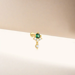 Macro detail of S925 sterling silver ear stud with green gemstone and zircon pendants