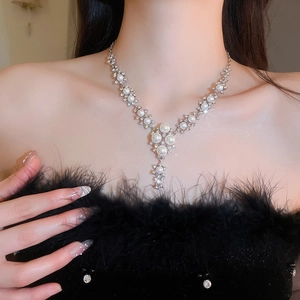 Close-up of model wearing an elegant floral pearl necklace with sparkling rhinestones