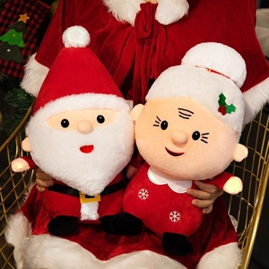 Detail of plush Santa Claus and Mrs. Claus dolls in festive red and white holiday outfits