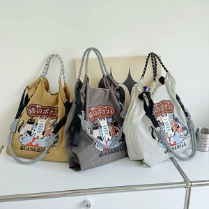 Detailed view of waterproof nylon tote bags with cat embroidery in yellow and grey