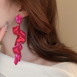 Close-up of elegant rose red petal fringe earrings on model featuring long tassel drop style