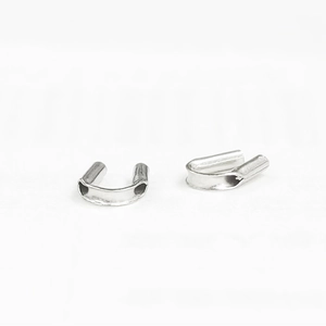 Macro view of silver U-shaped wire guardians for jewelry making and bead protection