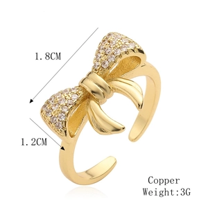 Dettaglio dell'anello a fiocco dorato in rame con dimensioni di 1,8 cm di larghezza e 1,2 cm