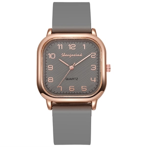 Detailed view of square rose gold watch case with grey striped dial and numeric markers