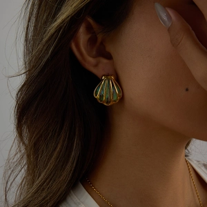 Detail eines 18K vergoldeten Muschelohrrings mit Abalone-Inlay an einem Model