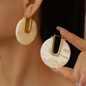 Close-up of U-shaped acetate earrings with 18k gold plating and marble texture
