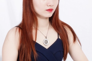 Detailed view of silver hollow tree pendant on model neck showing size and style
