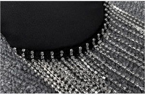 Detailed close-up of silver rhinestone tassels on a premium black blazer fabric